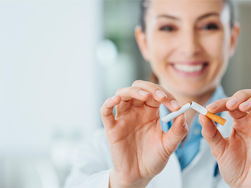 Stock image of woman holding broken cigarette in hands
