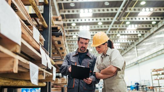 Stock image of 2 warehouse workers working together. 